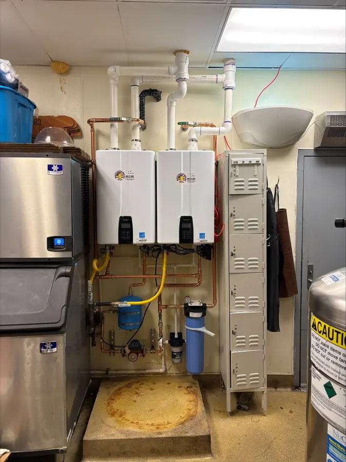 Tankless water heaters installed beside commercial tank units